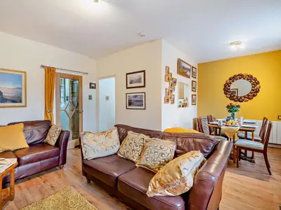 a living room with a leather couch and a dining room at 2 Bed in Keswick 80515 in Keswick