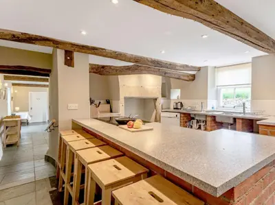 a large kitchen with a large island with wooden stools at 8 bed in Cockermouth 82453 in Bridekirk