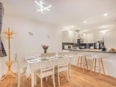 a white kitchen with a white table and chairs at 3 Bed in Threlkeld SZ217 in Threlkeld