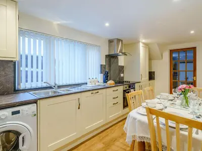 a kitchen with a table and a sink and a dishwasher at 3 Bed in Threlkeld 86613 in Threlkeld