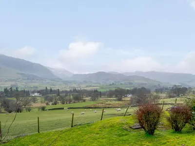 a herd of sheep grazing in a green field at 3 Bed in Threlkeld 86613 in Threlkeld