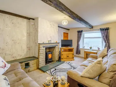 a living room with a couch and a fireplace at 3 Bed in Threlkeld 86613 in Threlkeld