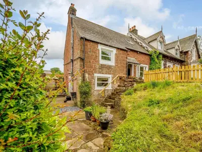 an old brick house with a wooden fence at 2 Bed in Egremont 87227 in Egremont