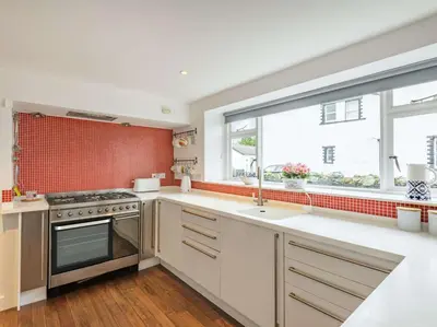 a kitchen with white cabinets and a large window at 4 Bed in Keswick oc-87567 in Keswick