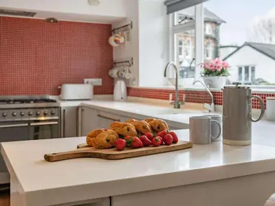a cutting board with muffins and strawberries on a kitchen counter at 4 Bed in Keswick oc-87567 in Keswick
