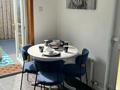 a small white table with blue chairs in a room at Tigh Lochlainn in Prestwick