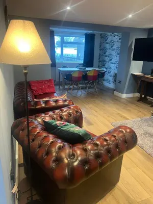 a brown leather couch sitting in a living room at The Ship Inn's Mill Cottage - Weavers Way in Gatehouse of Fleet