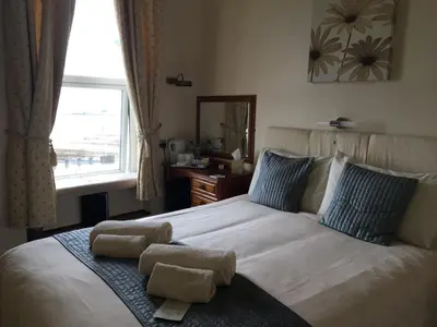 a bedroom with a bed with two towels on it at Cubbon House in Douglas
