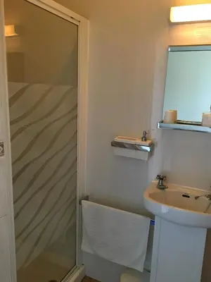 a bathroom with a shower and a sink at Cubbon House in Douglas