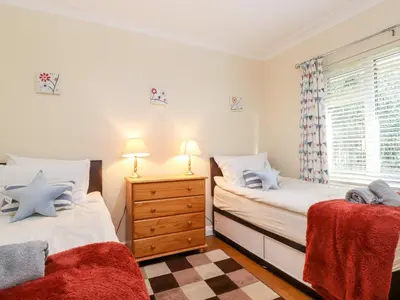 a bedroom with two twin beds and a window at Rainbow End in Ambleside