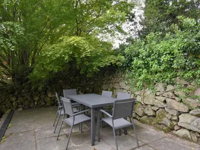 a table and chairs in front of a stone wall at 3 Bed in Eskdale SZ416 in Santon Bridge