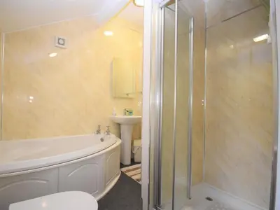a bathroom with a shower and a tub and a sink at 3 Bed in Eskdale SZ416 in Santon Bridge