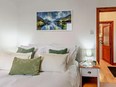 a white bed with pillows and a painting on the wall at 1 Bed in Keswick SZ516 in Keswick