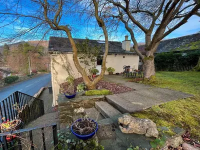 a house with a tree and some plants in a yard at 1 Bed in Keswick SZ516 in Keswick