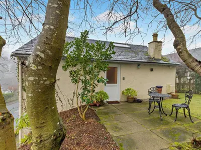 a small white house with a table and a chair at 1 Bed in Keswick SZ516 in Keswick