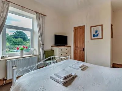 a bedroom with a white bed and a window at 3 Bed in Ullock SZ043 in Arlecdon