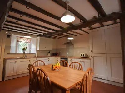 a kitchen with a wooden table and some chairs at 3 Bed in Pardshaw SZ419 in Dean