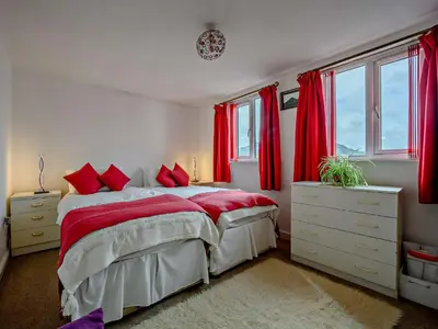 a bedroom with red curtains and a bed with red pillows at 1 Bed in Troutbeck SZ254 in Troutbeck