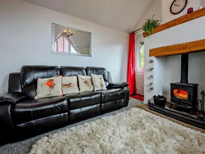 a black leather couch in a living room with a fireplace at 1 Bed in Troutbeck SZ254 in Troutbeck