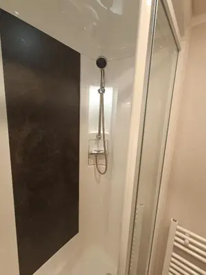 a bathroom with a shower with a light on the wall at Hillingworth's Hot Tub Retreat - Lochmaben in Dumfries