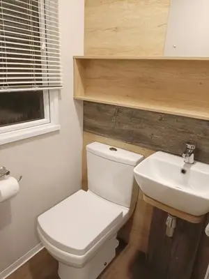 a bathroom with a white toilet and a sink at Hillingworth's Hot Tub Retreat - Lochmaben in Dumfries