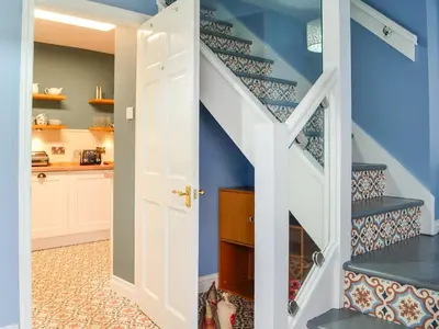 a staircase in a home with blue walls at The Smithy in New Galloway