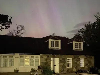 a rainbow in the sky above a house at The Smithy in New Galloway