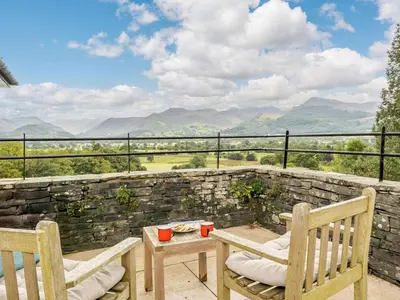 a patio with two chairs and a table with a view at 6 Bed in Keswick oc-89309 in Applethwaite
