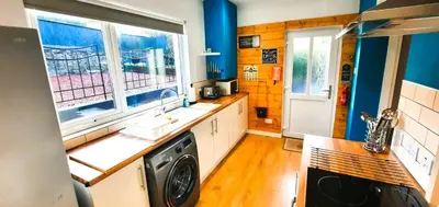 a kitchen with a sink and a washing machine at Tom's Place in Kirkcudbright