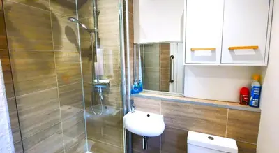 a bathroom with a shower with a toilet and a sink at Tom's Place in Kirkcudbright