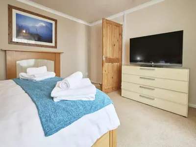 a bedroom with a bed with a television and towels at 2 Bed in Cockermouth SZ282 in Cockermouth