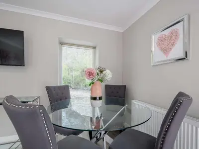 a dining room with a glass table and chairs at 1 Bed in Sandyhills 85904 in Fairgirth
