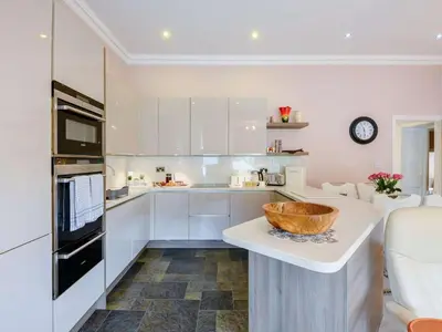 a kitchen with white cabinets and a bowl on a counter at 2 Bed in Portinscale 89261 in Portinscale