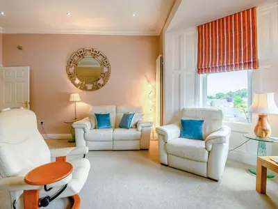 a living room with two white chairs and a table at 2 Bed in Portinscale 89261 in Portinscale