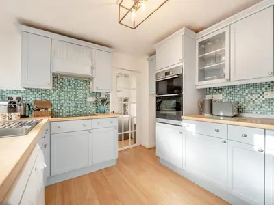 a white kitchen with white cabinets and wooden floors at 3 Bed in Keswick oc-89526 in Keswick