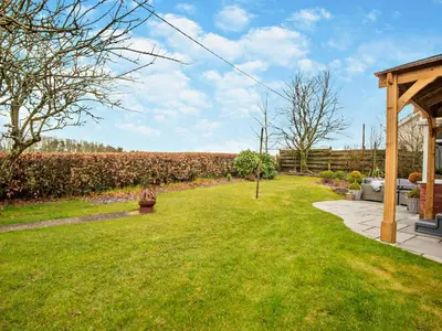a backyard with a yard with grass and a pavilion at 3 Bed in Cockermouth 82438 in Dearham