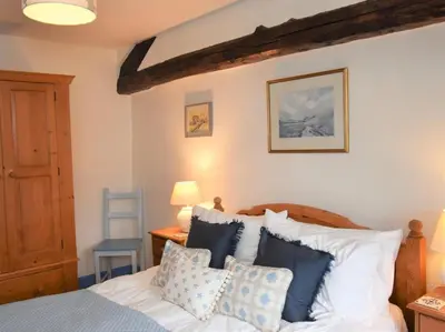 a bedroom with a bed with blue and white pillows at 3 Bed in Holmrook oc-sz313 in Boot