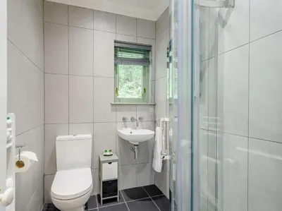 a white bathroom with a toilet and a sink at 3 Bed in Kippford 88274 in Kippford