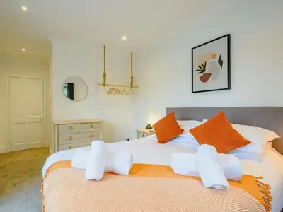 a bedroom with a bed with orange and white pillows at 3 Bed in Kippford 88274 in Kippford