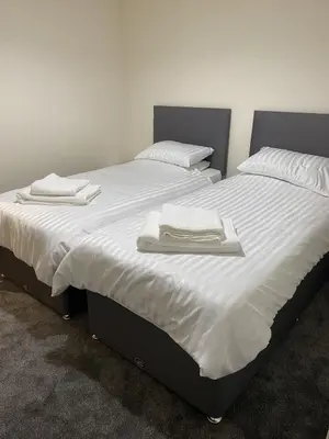 a large bed with two white towels on it at Craigielea Cottage in Newton Stewart