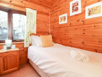 a bedroom with a bed in a log cabin at Latrigg Lodge in Keswick