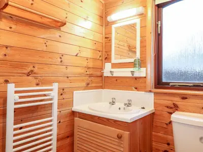 a bathroom with a sink and a toilet and a window at Latrigg Lodge in Keswick