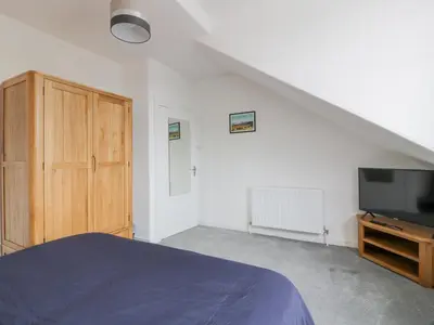 a bedroom with a bed and a flat screen tv at Little Ireland in Stranraer