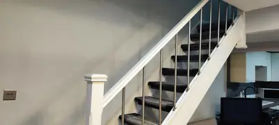 a staircase in a house with black tread stairs at A Whole Terrace house to you in Distington
