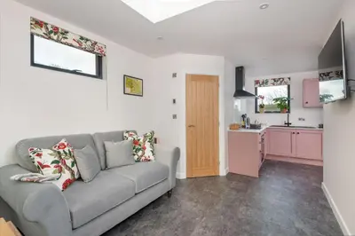 a living room with a couch and a kitchen at Crocus Penruddock, dog & eco friendly lodge with hot tub in Penruddock