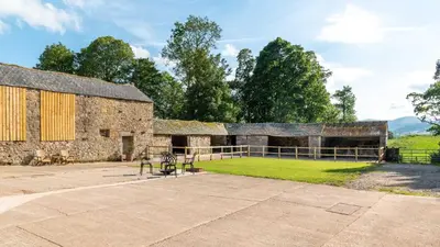 a stone building with a bench in front of it at Crocus Penruddock, dog & eco friendly lodge with hot tub in Penruddock