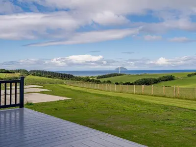 a wooden walkway with a fence and a field at 1 Bed in Turnberry 78071 in Girvan
