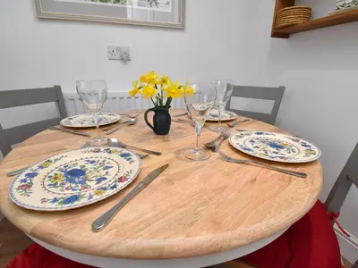 a wooden table with plates and glasses and flowers on it at 2 Bed in Caldbeck SZ212 in Caldbeck