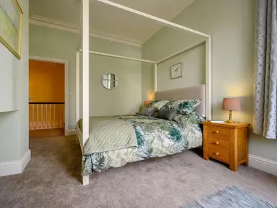 a bedroom with a canopy bed and a wooden nightstand at 3 Bed in Keswick 86867 in Keswick