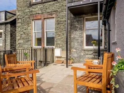 two wooden benches sitting on a patio in front of a building at 3 Bed in Keswick 86867 in Keswick